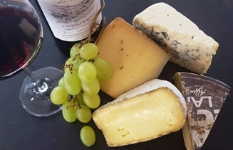 Weinglas und verschieden Sorten Käse